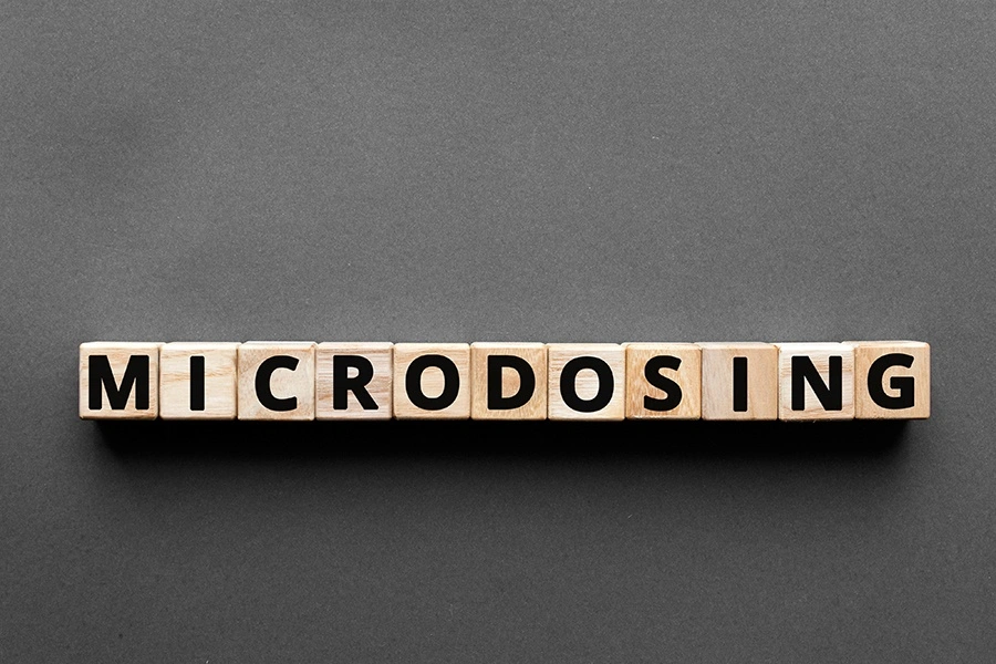 Letter blocks spelling "microdosing" on a gray background, representing alternative depression treatment